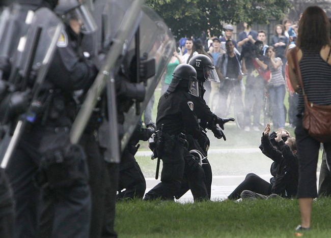 Riot police order some demonstrators to the ground and arrest them in Queens Park, Toronto, Saturday, June 26, 2010, as the G20 Summit gets underway.
