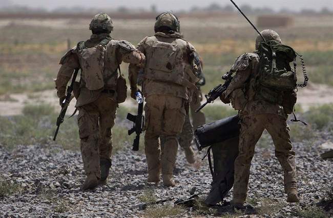 Canadian soldiers help a comrade, center, get on a helicopter after he was injured in an IED blast during a patrol outside Salavat, in the Panjwayi district, southwest of Kandahar, Afghanistan, Monday, June 7, 2010. 