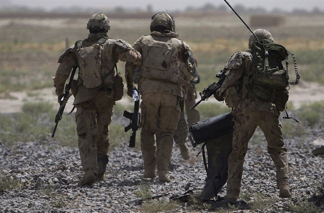 Canadian soldiers help a comrade, center, get on a helicopter after he was injured in an IED blast during a patrol outside Salavat, in the Panjwayi district, southwest of Kandahar, Afghanistan, Monday, June 7, 2010. 
