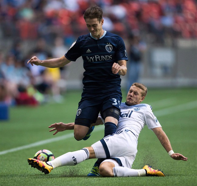 Vancouver Whitecaps' Brett Levis, right, slides to take the ball away from Sporting Kansas City's Cameron Porter during a game in 2016. Levis has been signed with Winnipeg's Valour FC.