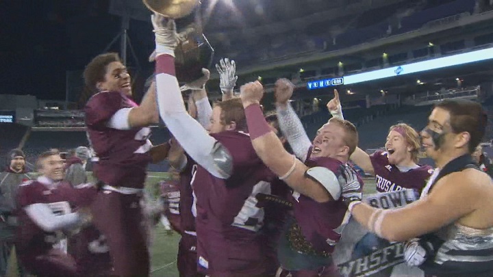 The St. Paul's Crusaders hoist the trophy after winning the ANAVETS Bowl on Thursday at Investors Group Field.