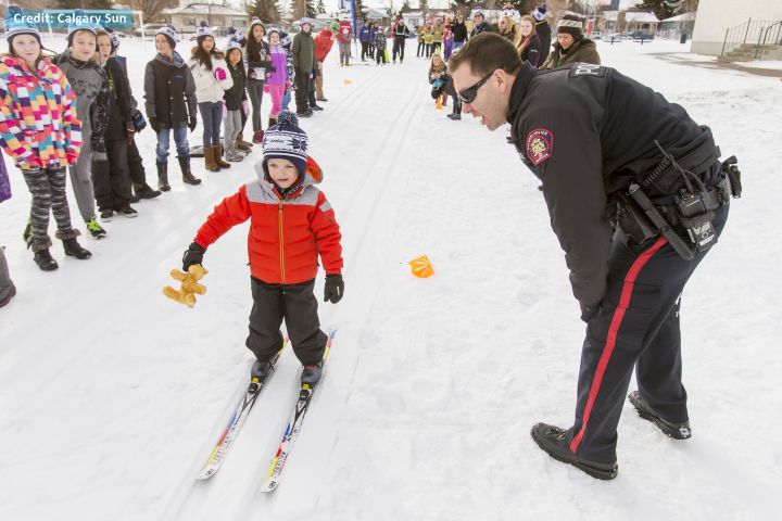 FILE: Const. Denis McHugh encourages a young boy as he skis by at Mount View School in Calgary, Alta., on Tuesday, Jan. 26, 2016. 