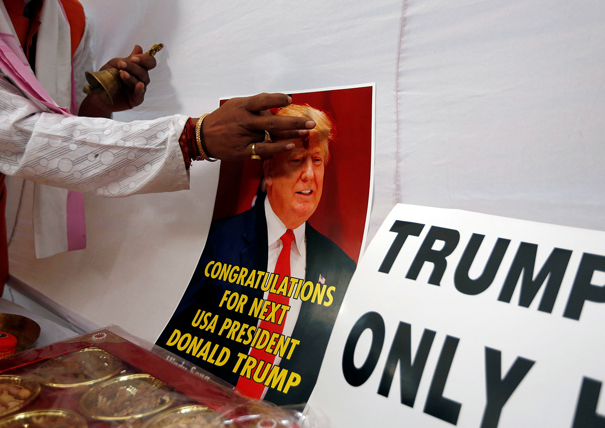 A member of Hindu Sena, a right-wing Hindu group, applies a spiritual mark "tilak' on a poster of U.S. Republican presidential nominee Donald Trump as they symbolically celebrate his victory in the upcoming U.S. elections, in New Delhi, India, November 4, 2016.