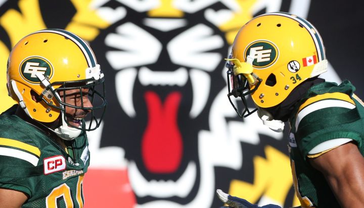 Edmonton Eskimos running back John White (30) celebrates one of his touchdowns with teammate Edmonton Eskimos cornerback Garry Peters (34), right, during the first-half of CFL eastern semi-final football action, in Hamilton, Ont., on Sunday, November 13, 2016. 