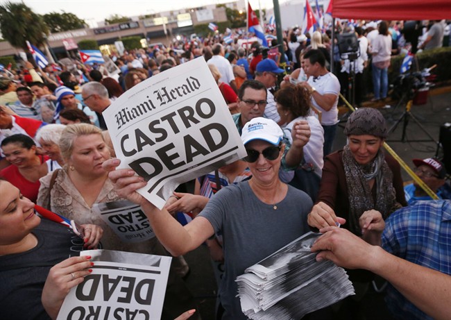 Alexandra Villoch, president and publisher of the Miami Herald Media Company, hands out a special edition of the Miami Herald with the headline "Castro Dead," in front of the Versailles Restaurant in the Little Havana neighborhood of Miami as members of the Cuban community react to the death of Fidel Castro, Saturday, Nov. 26, 2016. Castro, who led a rebel army to improbable victory in Cuba, embraced Soviet-style communism and defied the power of 10 U.S. presidents during his half century rule, died at age 90. (AP Photo/Wilfredo Lee).