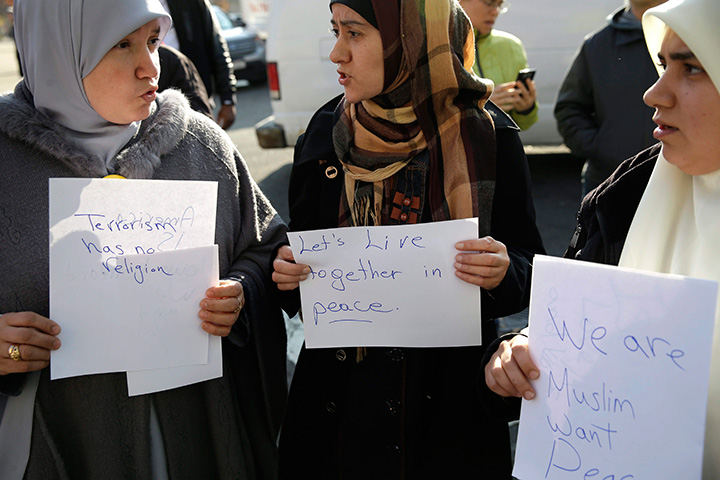 Amina Ismail, left, Fatima Amaziane, centre, and Dalia Abdallah hold signs during a news conference in the Queens borough of New York, Thursday, Dec. 10, 2015. 