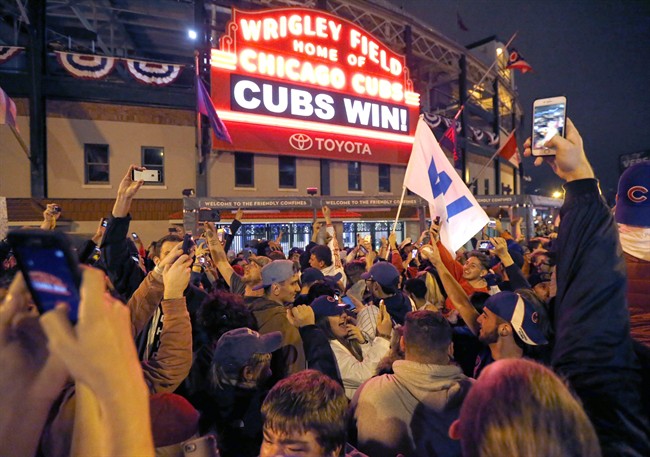Chicago Cubs fans celebrate in front of Wrigley Field in Chicago on Wednesday, Nov. 2, 2016, after the Cubs defeated the Cleveland Indians 8-7 in Game 7 of the baseball World Series in Cleveland. 