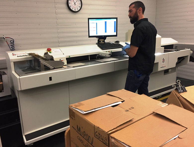 An employee feeds documents through the high-speed scanner.