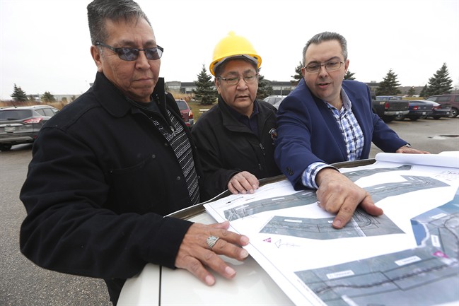 From left, Daryl Redsky, consultation officer, Chief Erwin Redsky, both of Shoal Lake 40 First Nation, and Phil Cesario, design project manager at PM Associates Ltd. go over the final design drawings for Freedom Road, an all-weather road which will connect the reserve to the Trans Canada highway, in Winnipeg on Friday.