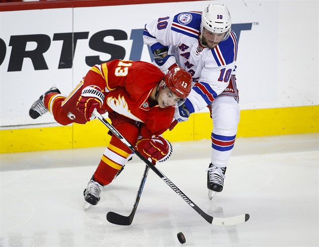 New York Rangers' J.T. Miller, right, battles with Calgary Flames' Johnny Gaudreau during second period NHL hockey action in Calgary, Saturday, Nov. 12, 2016.