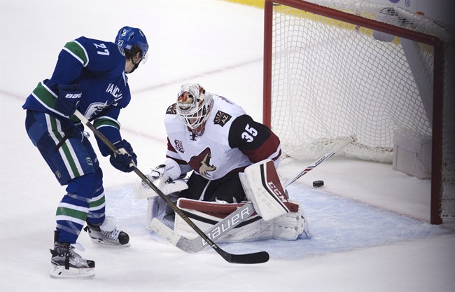 Vancouver Canucks defenceman Ben Hutton (27) scores the game winning goal past Arizona Coyotes goalie Louis Domingue (35) during overtime NHL action in Vancouver, B.C. Thursday, Nov. 17, 2016. 