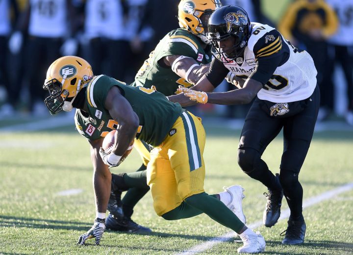 Edmonton Eskimos' Kenny Ladler (37) scrambles away after intercepting a pass as Hamilton Tiger Cats' Terrence Toliver (80) gives chase during second half CFL playoff action, in Hamilton, Ont., on Sunday, November 13, 2016. 