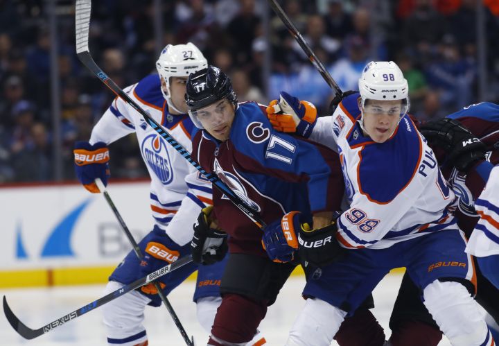 Colorado Avalanche right wing Rene Bourque, center, fights while pursuing the puck with Edmonton Oilers right wing Jesse Puljujarvi, right, of Sweden, and Edmonton Oilers left wing Milan Lucic in the first period of an NHL hockey game, Wednesday, Nov. 23, 2016, in Denver. 