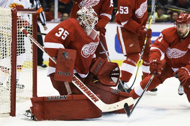 Detroit Red Wings goalie Jimmy Howard (35) deflects the puck against the Calgary Flames during the first period of an NHL hockey game in Detroit, Sunday, Nov. 20, 2016. 
