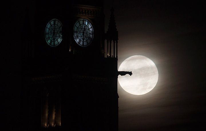 The moon is seen setting behind the Parliament buildings Monday November 14, 2016 in Ottawa.