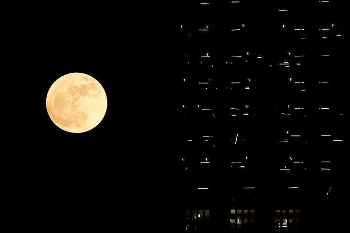 The supermoon is seen behind a building under construction in Hong Kong, November 14, 2016.
