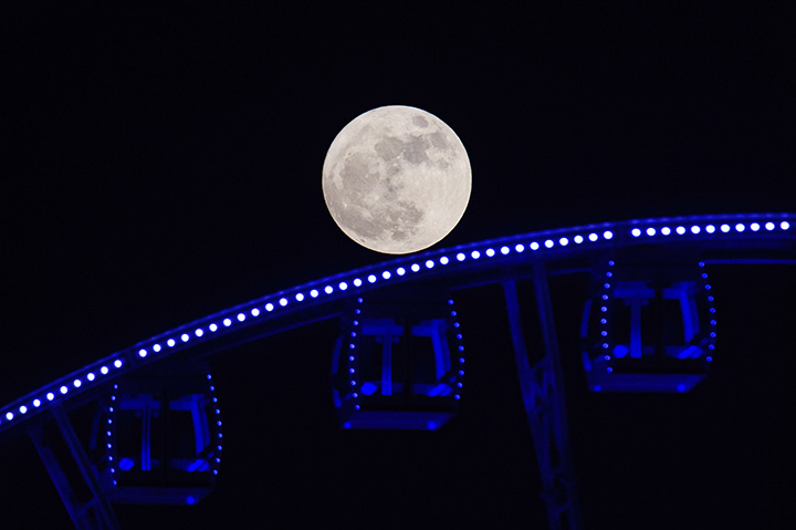 A supermoon is seen rising beyond a Ferris wheel in Hong Kong on November 14, 2016.