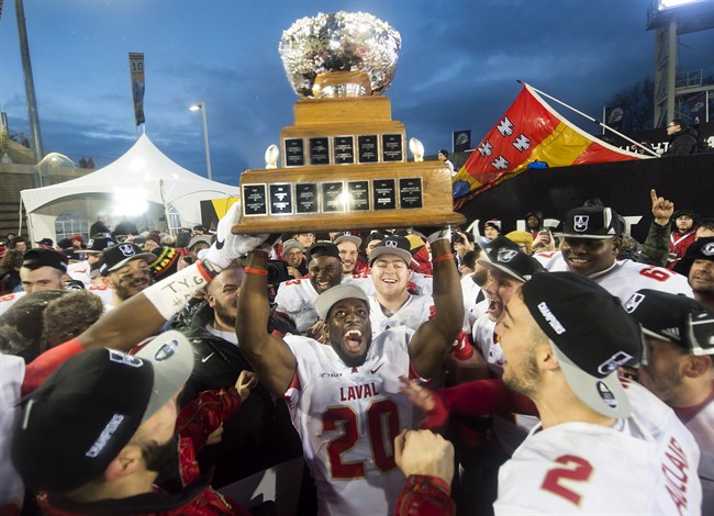 Laval Rouge et Or's Christopher Amoah (20) hoists the Vanier Cup after defeating the Calgary Dinos to win the U Sports Vanier Cup football championship, in Hamilton, Ont., on Saturday, November 26, 2016.