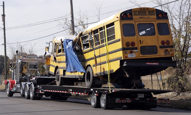 In this Nov. 22, 2016, file photo, a school bus is carried away in Chattanooga, Tenn., from the site where it crashed, killing several young students.