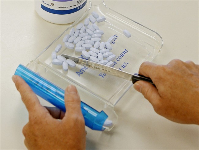 In this 2010 file photo, a pharmacy technician poses for a picture with prescription medication at a pharmacy.