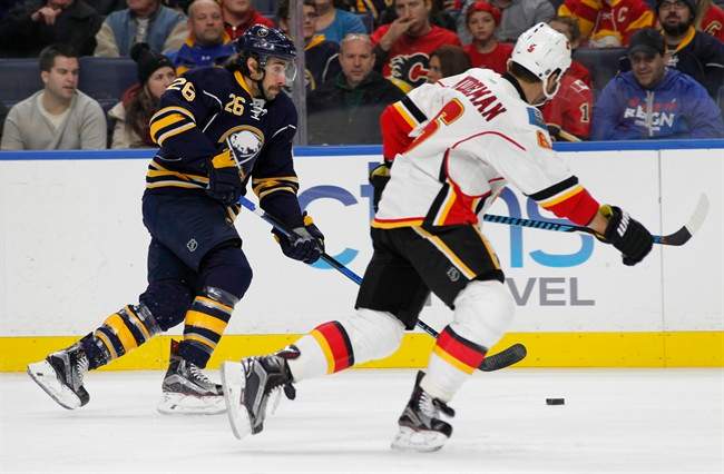 Buffalo Sabres forward Matt Moulson (26) and Calgary Flames defenseman Dennis Wideman race towards the puck during the first period of an NHL hockey game, Monday, Nov. 21, 2016, in Buffalo, N.Y. 