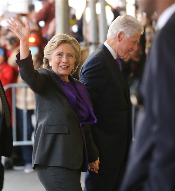 Hillary Clinton, holding hands with her husband, former President Bill Clinton, waves to a crowd outside a New York hotel as she arrives to speak to her staff and supporters after losing the race for the White House, Wednesday, Nov. 9, 2016.