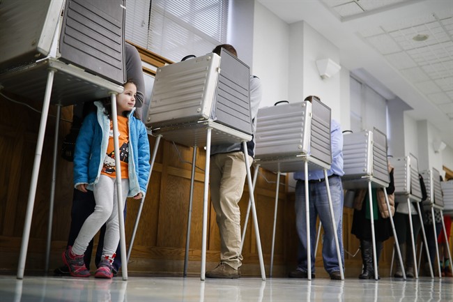 Violet Lay waits beside her mother Susan to finish voting in a polling booth in Cincinatti on Election Day.