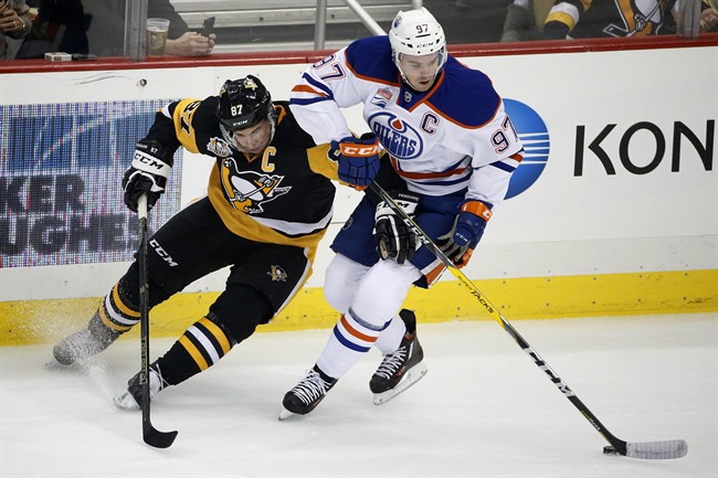 Edmonton Oilers' Connor McDavid (97) and Pittsburgh Penguins' Sidney Crosby (87) compete for the puck during the first period of an NHL hockey game in Pittsburgh, Tuesday, Nov. 8, 2016. 