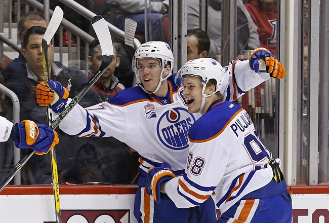 Edmonton Oilers center Connor McDavid, left, celebrates his goal against the Arizona Coyotes with right wing Jesse Puljujarvi (98) during the first period of an NHL hockey game Friday, Nov. 25, 2016, in Glendale, Ariz. (AP Photo/Ross D. Franklin).