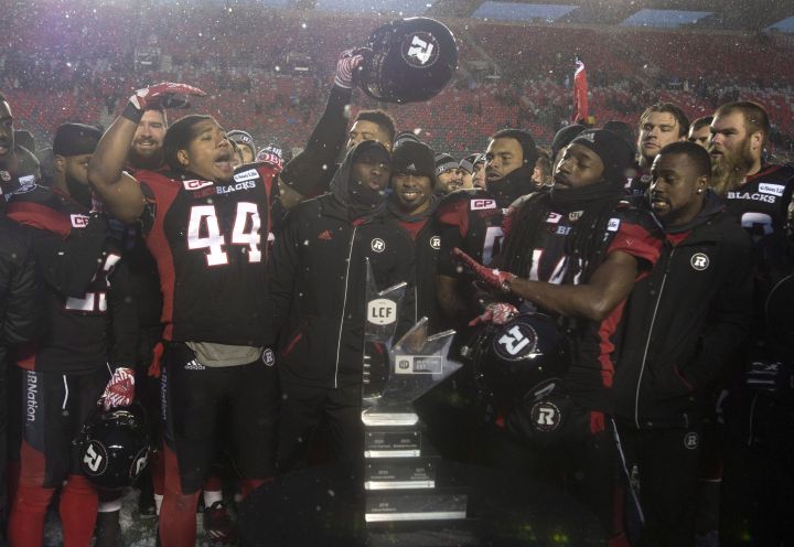 Ottawa Redblacks players celebrate in front of the Eastern Division trophy after defeating the Edmonton Eskimos 35-23 following the CFL Eastern Final, in Ottawa on Sunday, November 20, 2016. 