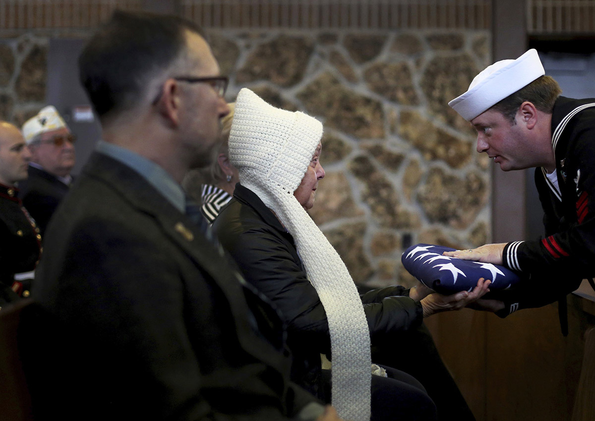 Diane Reiman, second left, sister of Vietnam veteran Stephen Carl Reiman, accepts the flag from her brother's casket during his funeral Tuesday morning, Nov. 29, 2016 at the Oregon Trail State Veterans Cemetery in Evansville, Wyo. Stephen Carl Reiman, who served in the Navy during the Vietnam war, died Nov. 17 in Casper shortly after traveling to Wyoming from Southern California. Reiman appeared to have no family until his sister was finally located. 
