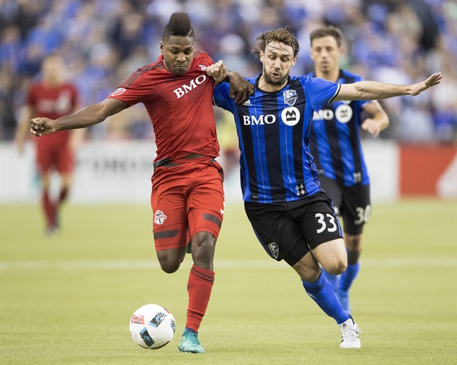 Montreal Impact midfielder Marco Donadel (33) and Toronto FC's Armando Cooper, left, battle for the ball during first half action in the first leg of the MLS Eastern Conference final at the Olympic Stadium in Montreal, Tuesday, November 22, 2016. THE CANADIAN PRESS/Ryan Remiorz.