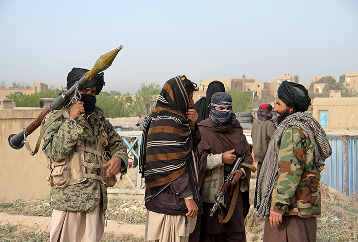 Members of the Taliban gather at the site of the execution of three men accused of murdering a couple during a robbery in Ghazni province, Afghanistan April 18, 2015.  