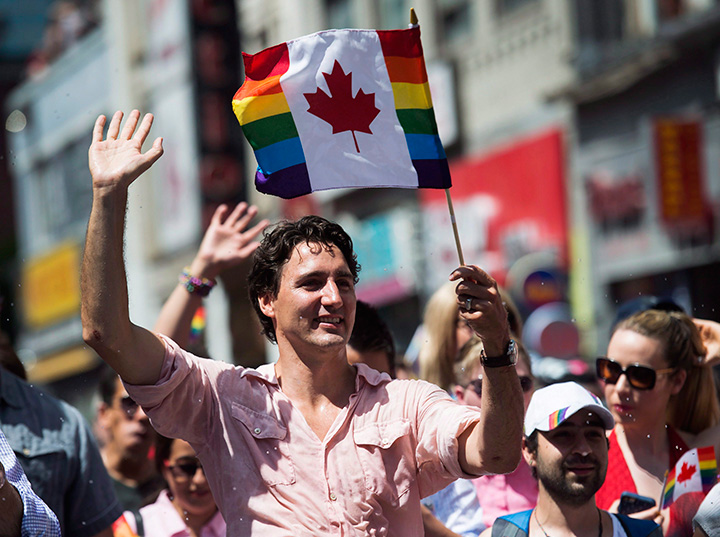 Prime Minister Justin Trudeau waves a flag as he takes part in the annual Pride Parade in Toronto on Sunday, July 3, 2016. 