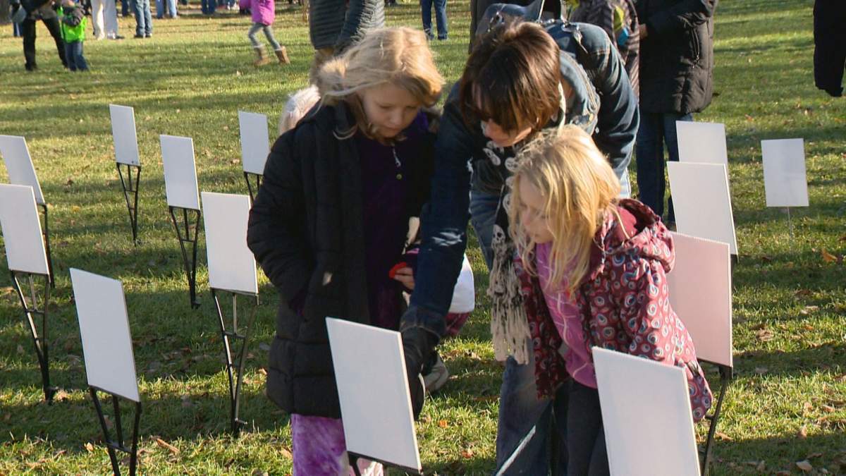 Corie White looks at Chris Harris’ soldier grave photos with her daughters.