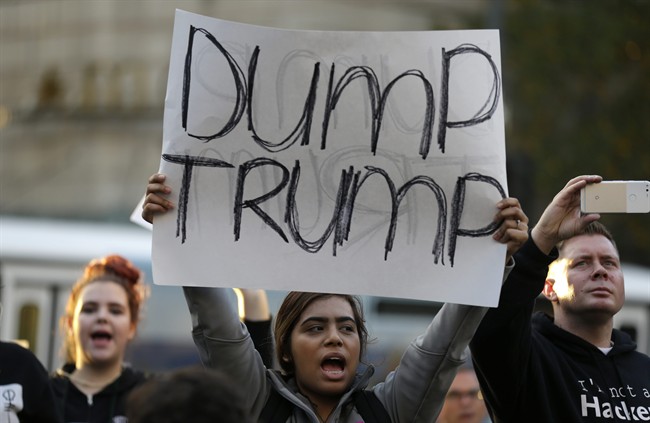 A protester holds a sign that reads "Dump Trump" as she takes part in a protest against the election of President-elect Donald Trump, Wednesday, Nov. 9, 2016, in downtown Seattle.