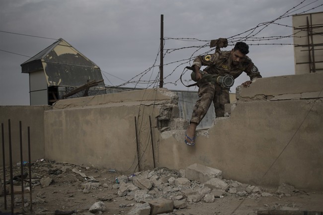 An Iraqi special forces fighter moves between buildings near the front line during fighting with Islamic State militants, in eastern Mosul, Iraq, Tuesday, Nov. 15, 2016. (AP Photo/Felipe Dana).