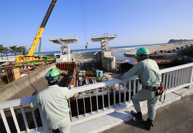 Workers look at a floodgate under construction after a tsunami warning was lifting in Fukushima on Nov. 22, 2016. 