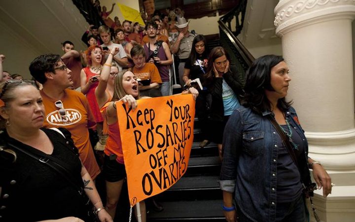 Abortion rights advocates, left, protest in the State Capitol as anti-abortion rights supporters pass them in Austin, Texas. 
