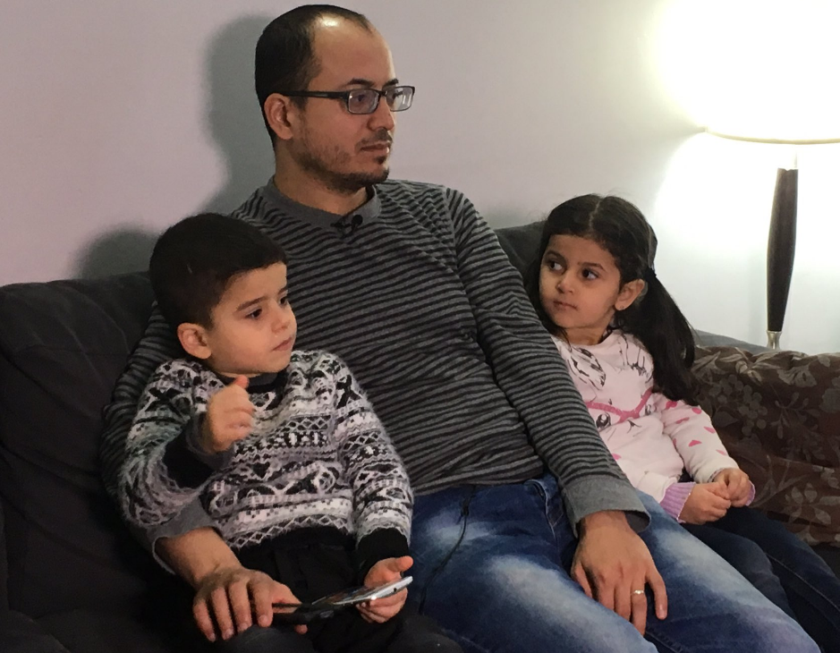 Abu Abdo watches the latest news on Aleppo, as he sits with his family in Winnipeg.