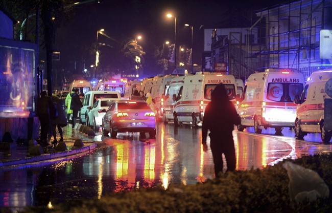 Medics and security officials work at the scene after an attack at a popular nightclub in Istanbul, early Sunday, Jan. 1, 2017. Turkey's state-run news agency says an armed assailant has opened fire at a nightclub in Istanbul during New Year's celebrations, wounding several people.(IHA via AP).