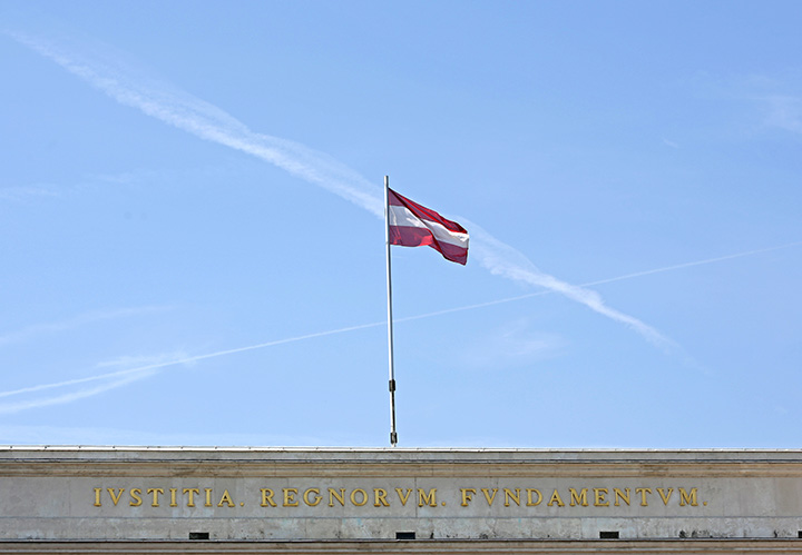 The Austrian national flag flies on top of the Burgtor, near the Hofburg Palace, in Vienna, Austria, on Saturday, July 4, 2015. 