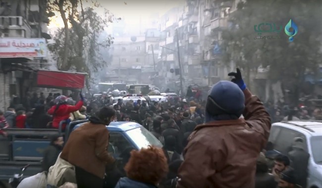 This frame grab from video provided by Baladi News Network, a Syrian opposition media outlet that is consistent with independent AP reporting, shows civilians gathering for evacuation from eastern Aleppo, Syria, Thursday, Dec. 15, 2016. The Russian military said over 1,000 people have been evacuated from Aleppo under a cease-fire deal reached with Syrian rebels. France's ambassador to the United Nations says international observers should monitor the safe evacuation of civilians and fighters from the war-torn Syrian city of Aleppo. (Baladi News Network via AP).