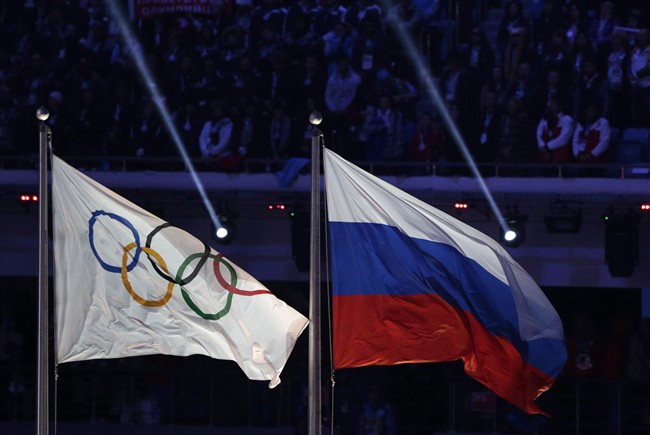 The Russian national flag flies next to the Olympic flag during the closing ceremony of the 2014 Winter Olympics in Sochi, Russia on Feb. 23, 2014. 