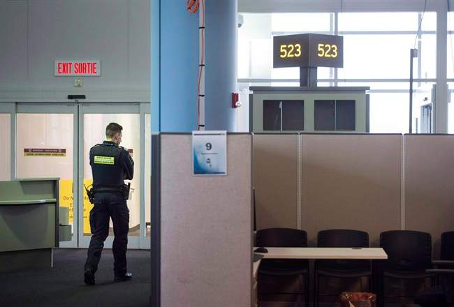 A Canadian Border Services agent stands watch at gate at Pearson International Airport in Toronto on Tuesday, December 8, 2015. Proposed legislation will expand border preclearance at Canadian airports and other crossings.