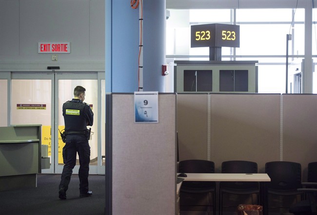 A Canadian Border Services agent stands watch at gate at Pearson International Airport in Toronto on Tuesday, December 8, 2015. Proposed legislation will expand border preclearance at Canadian airports and other crossings.