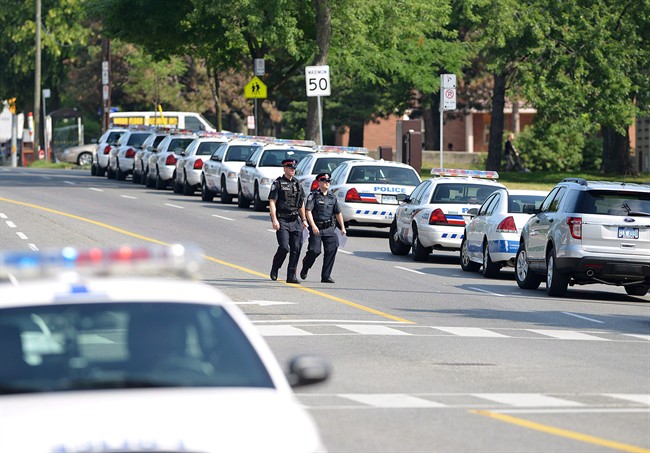 Police cars line the side of Morningside Ave in Toronto on Tuesday July 17, 2012 near the scene of a shooting on Danzig Street where 19 people were injured and 2 confirmed dead at an outdoor barbecue that took place onJuly 16.