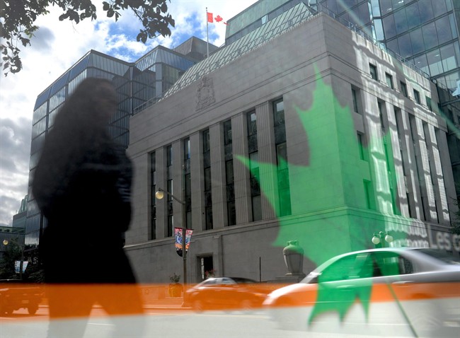The Bank of Canada is reflected in signage on a bus stop in Ottawa on Tuesday, September 6, 2011. 