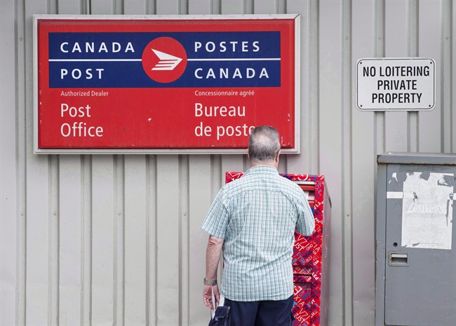 File Photo. A man mails a letter outside a Canada Post office in Halifax on July 6, 2016.