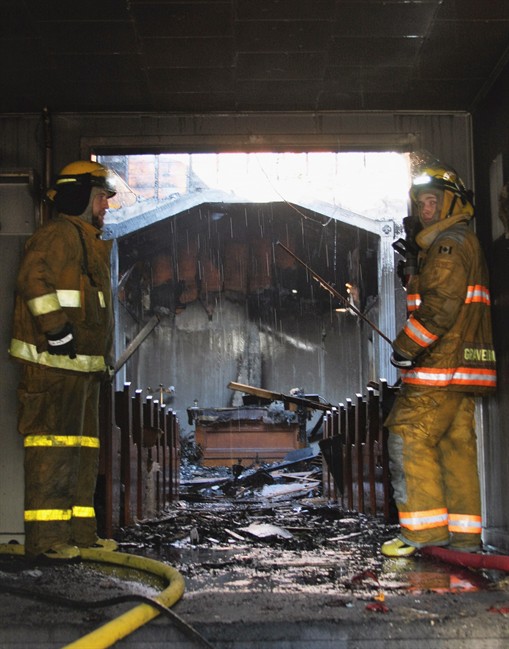 Firefighters survey damage caused by a fire at a church in Gravelbourg, Sask. in this undated handout photo. Parishioners of a Lutheran church in a small town in Saskatchewan are upset after their place of worship was extensively damaged in a fire.